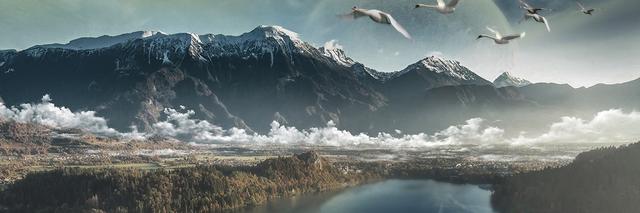 Panoramablick auf schneebedeckte Berge, ein nebliges Tal und einen ruhigen See mit fliegenden Vögeln.